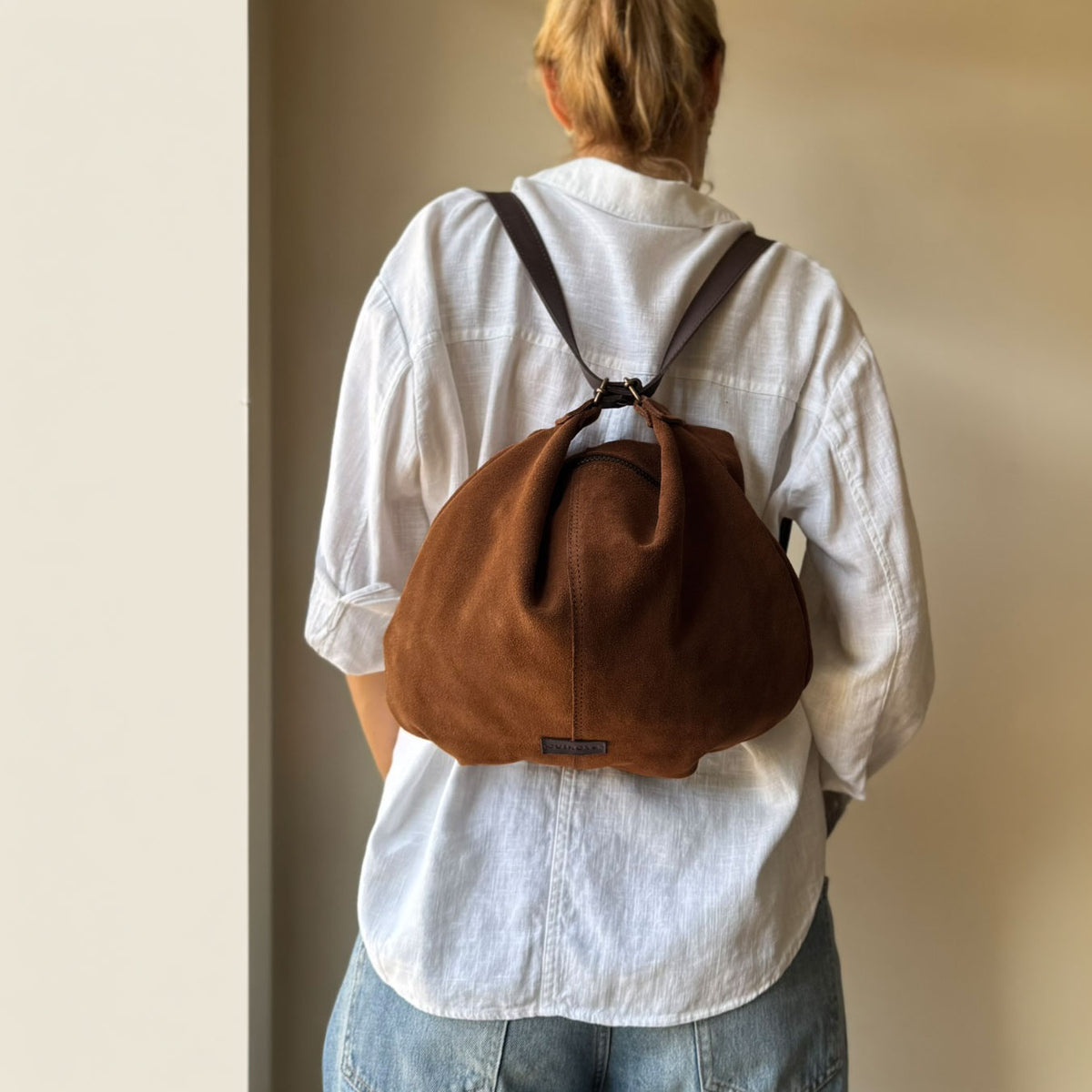 Bolso mochila Zoe de serraje en color cuero, llevado como mochila