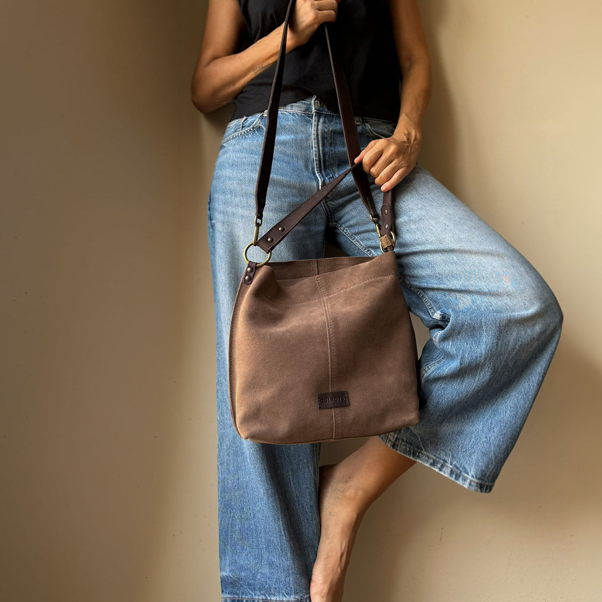 Bolso de hombro y bandolera Zoe de serraje en color taupe, colgado al hombro