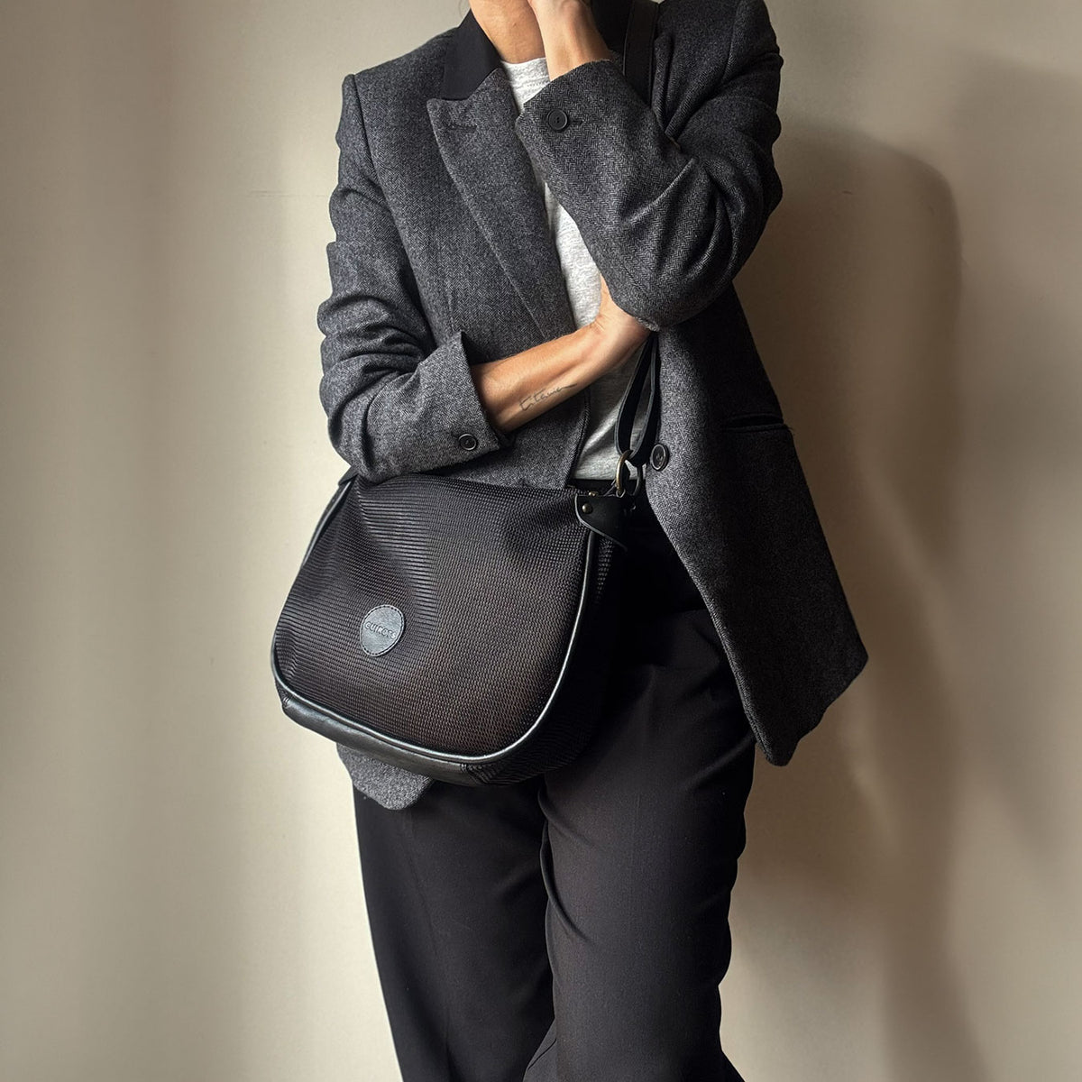 Bolso bandolera Treck de rejilla en color negro, llevado al hombro